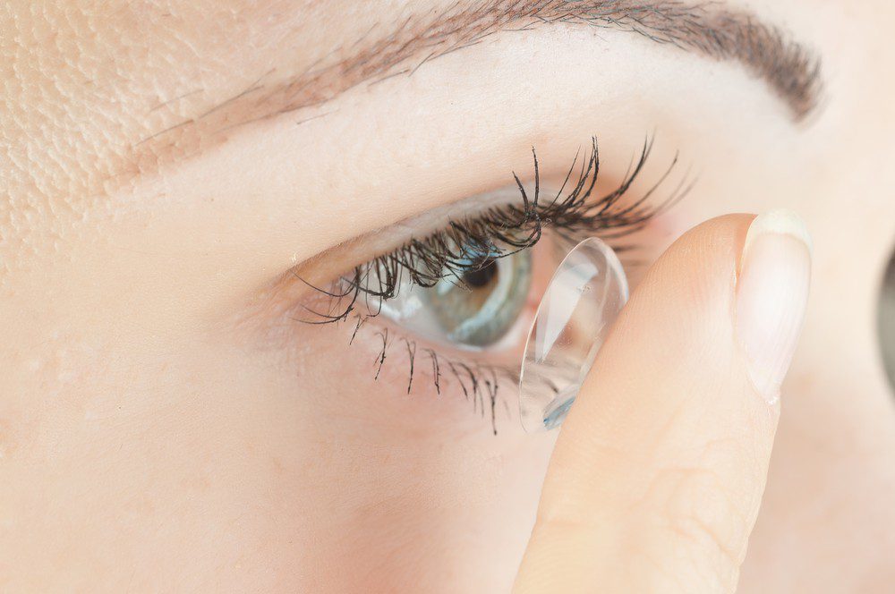 A close-up of a person’s eye as they use their finger to place a contact lens, captured in fine detail—highlighting the expertise found at Vu, lunetterie à Montréal.